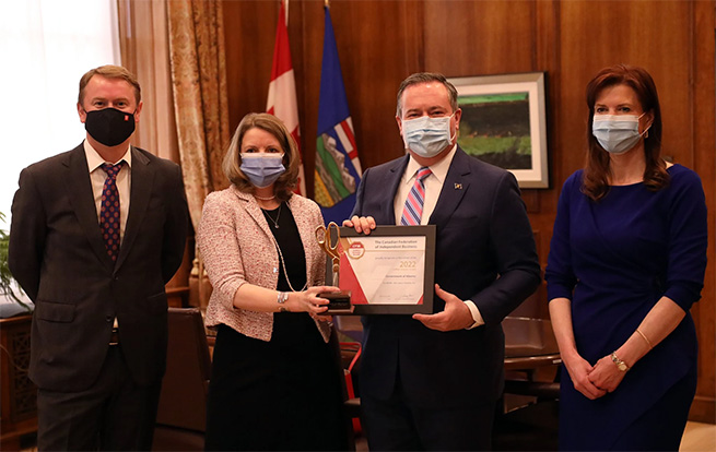 Alberta government officials and CFIB representatives holding the Golden Scissors award